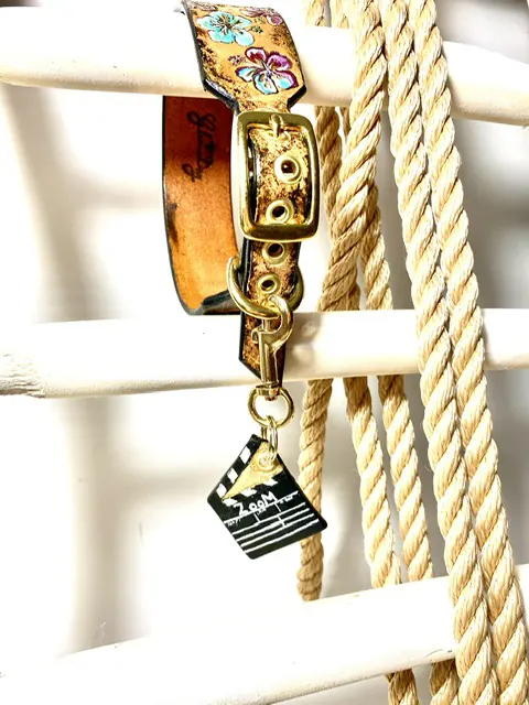 Goldfarbenes Halsband mit einer Ledermarke in Form einer Filmklappe