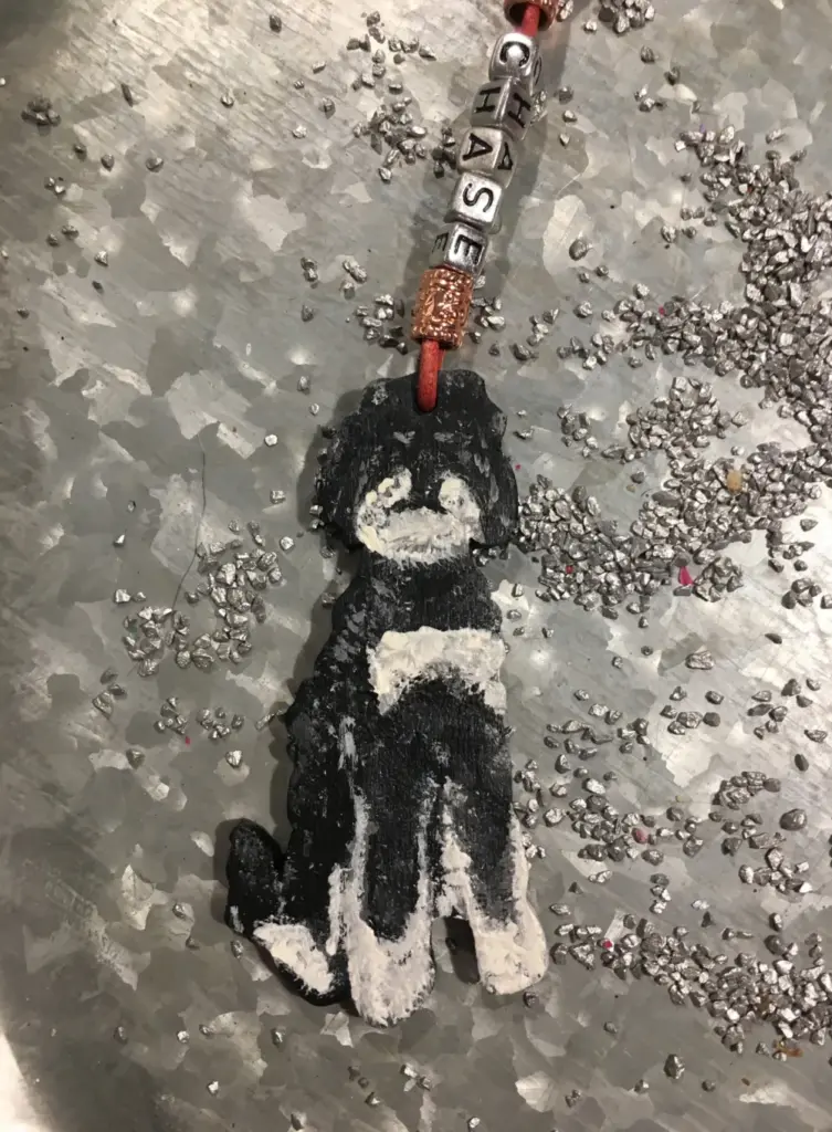 Lederhalsband mit punziertem Hundeportrait, auf Asphalt fotografiert